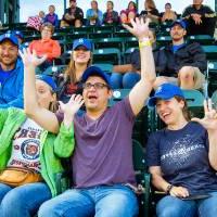 Photo of a group of people cheering and doing the laker up symbol